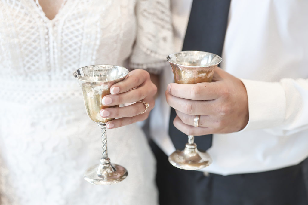 silver wedding cups cheers by bride and groom
