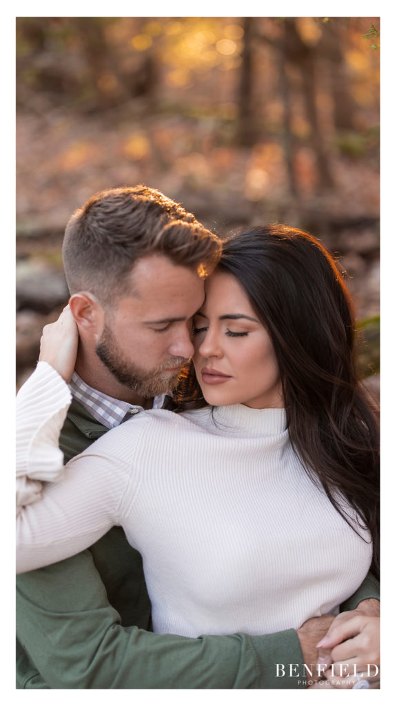 romantic pose of a guy hugging a girl from behind during sunrise engagement session