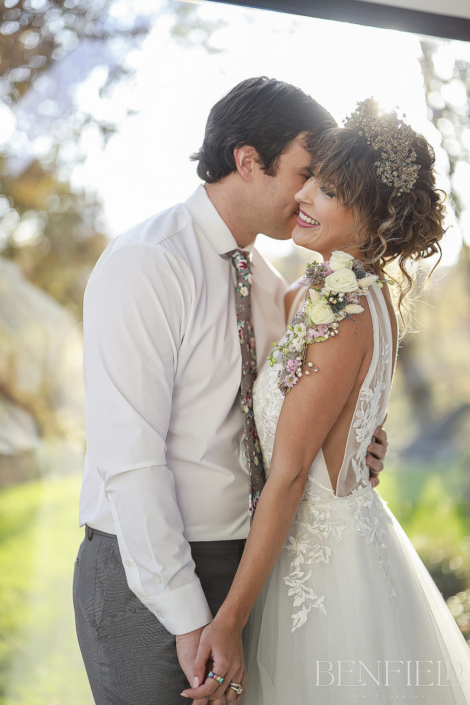 Weddings at Osage House with groom kissing brides neck