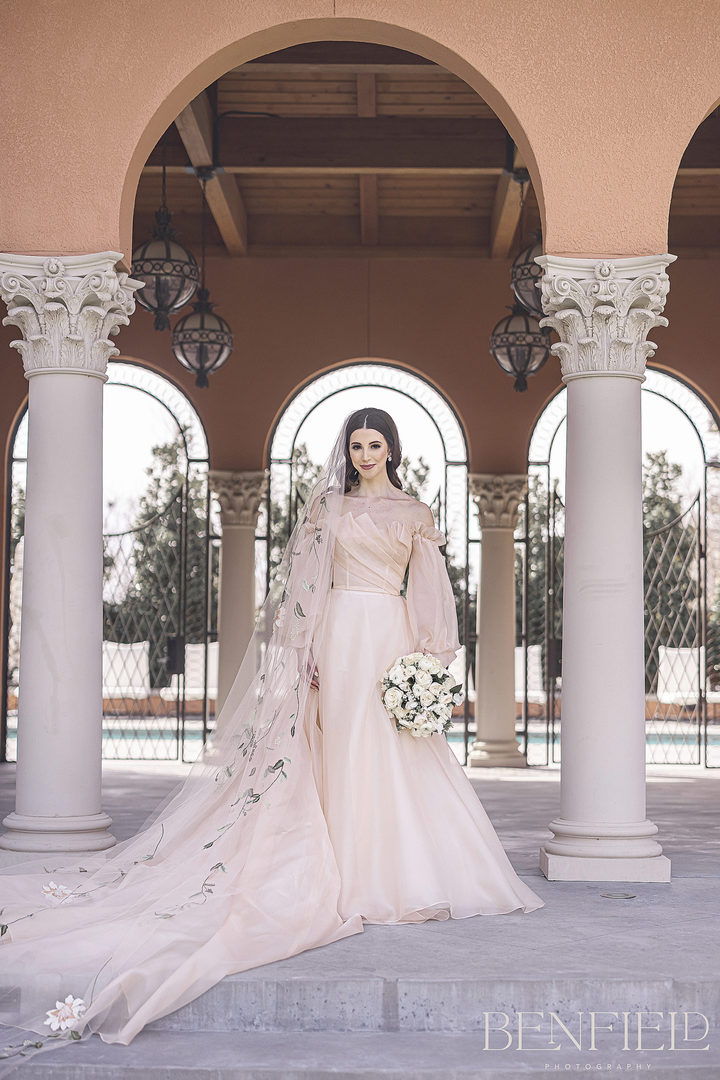 Monique Lhuillier Bridal Portraits of a young bride in a soft pink wedding dress that is strapless with a long train. This designer luxury bridal gown was photographed in Dallas Texas.