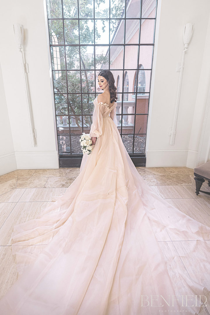 Monique Lhuillier Bridal Portraits of a young bride in a soft pink wedding dress that is strapless with a long train. This designer luxury bridal gown was photographed in Dallas Texas.