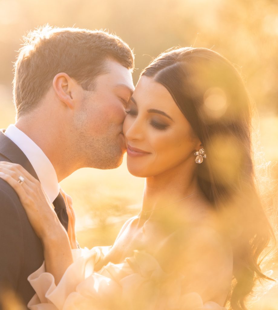 Sunset golden hour wedding portrait of bride and groom after their wedding ceremony at The Hillside Estate in Cross Roads, TX