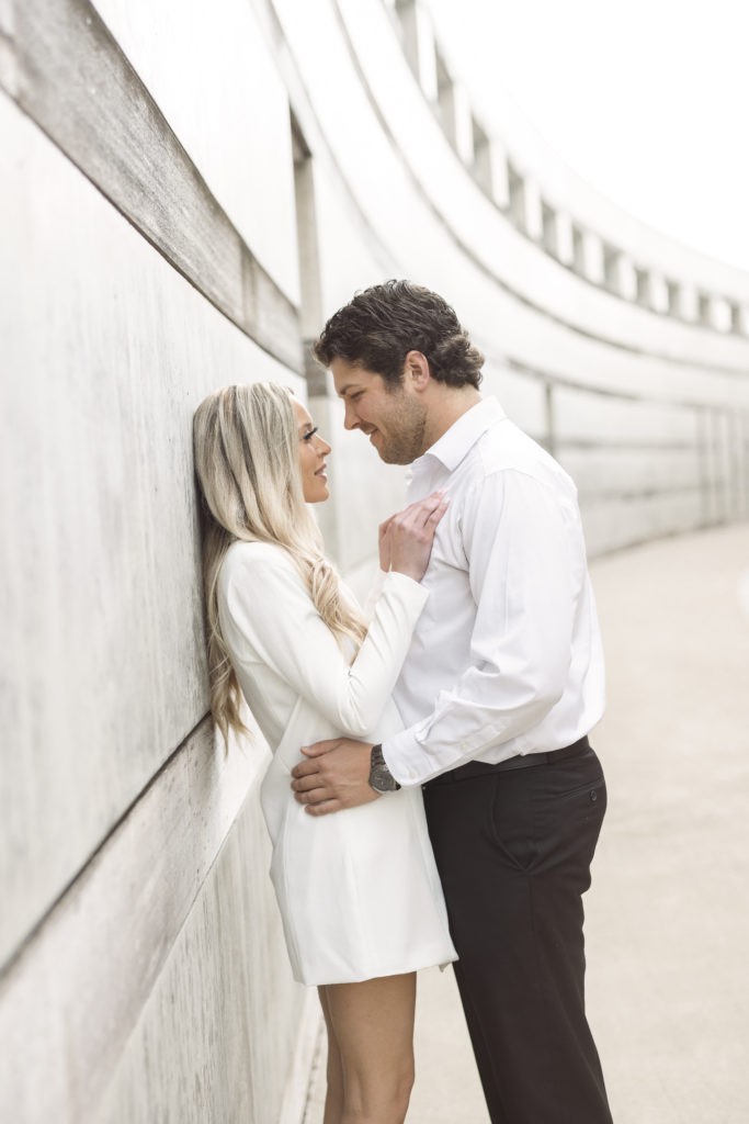 young couple hold each other during their engagement portraits at crystal bridges in bentonville ar