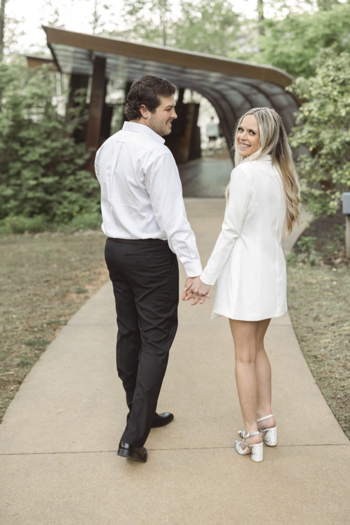 young couple hold each other during their engagement portraits at crystal bridges in bentonville ar