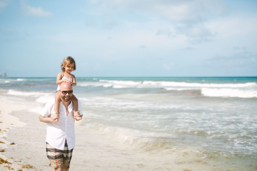 Beach family pictures at the Ritz-Carlton in Cancun of a dad and daughter walking along the beach.