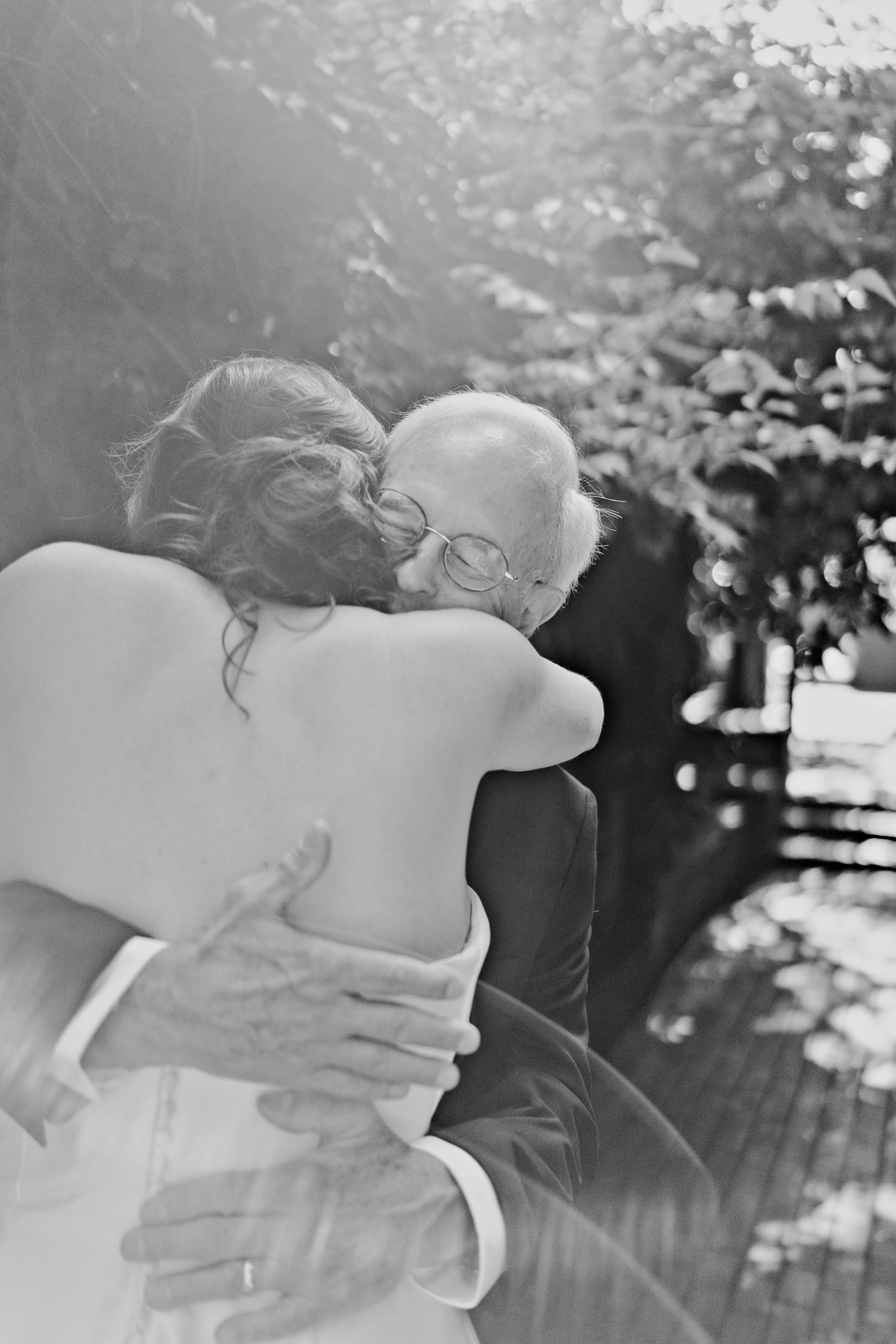 Father and daughter embrace during their first look for her Fayetteville Garden Room wedding.