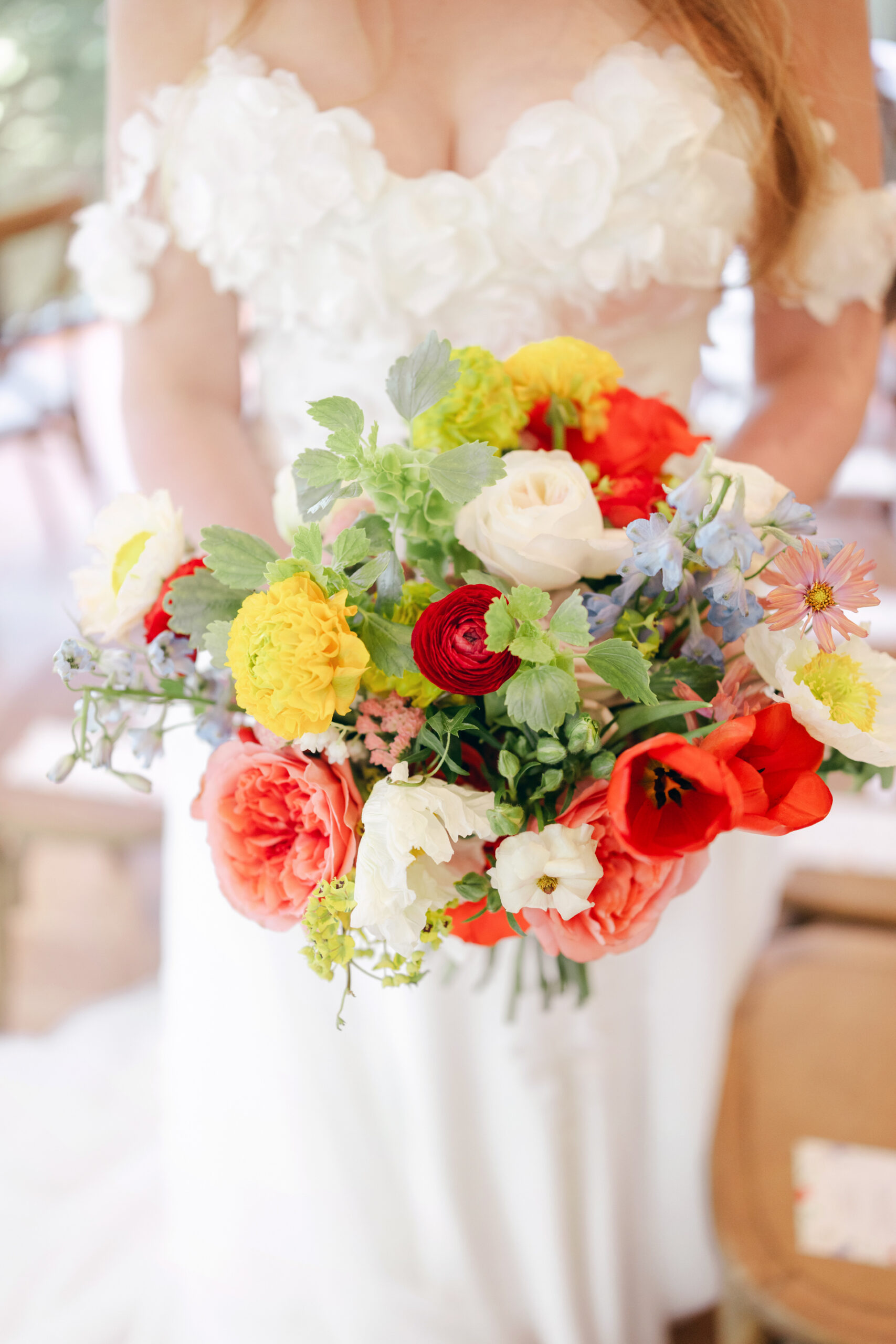 Colorful bridal bouquet with ranunculus roses and spring flowers at Bentonville garden wedding