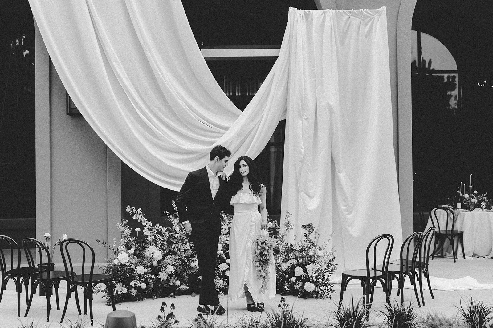 Bride and groom beneath dramatic white ceremony draping and florals at Hotel Vin Rogers in Rogers, Arkansas.