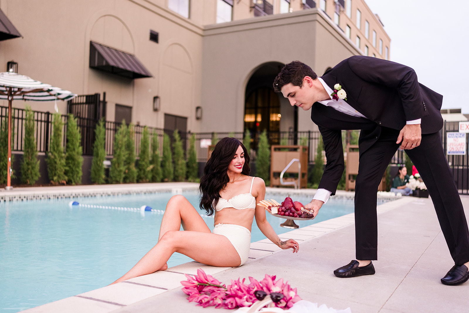 Groom bringing charcuterie to the bride beside the pool at Hotel Vin Rogers.
