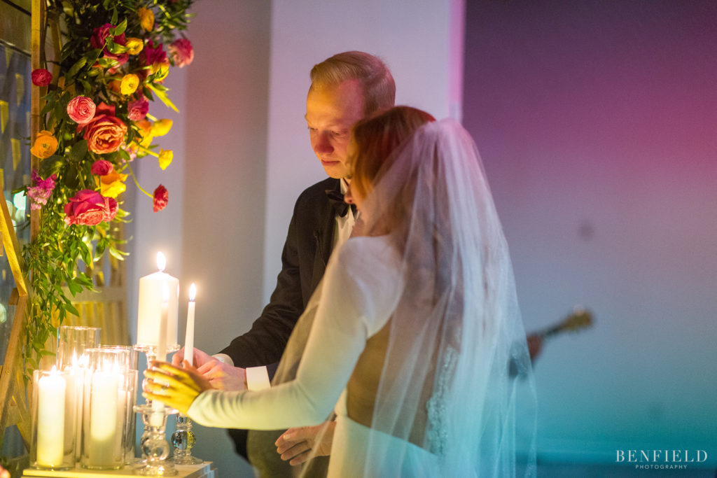 romantic image of the bride and groom lighting their unity candle at the gallery event space in kansas city on new years eve.