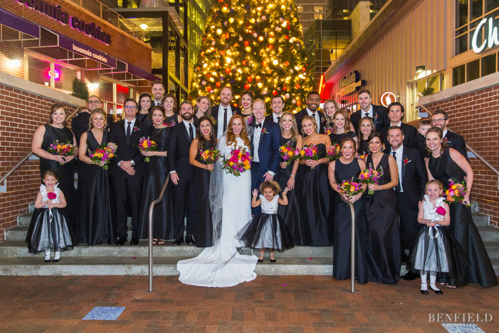 huge wedding party picture with nearly 20 bridesmaids at the power and light district in kansas city on new years eve.