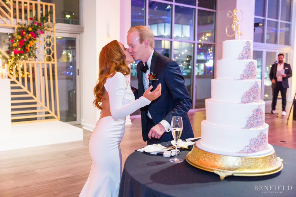 the bride and groom cut their designer wedding cake with a sprinkle design at the Gallery Event Space in Kansas City on new years eve.