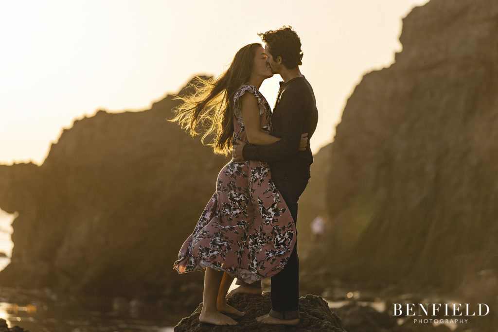 couple kissing at sunset on el matador beach for their engagement pictures
