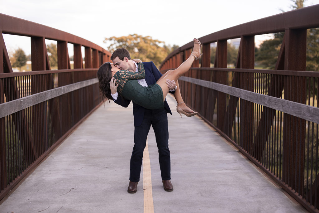 engaged couple dipping on a bridge in the fall