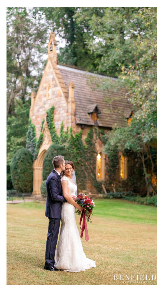 bride and groom kissing in front of a chapel cottage in Arkansas
