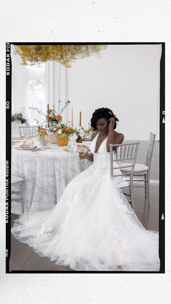 beautiful black bride in white gown sitting at a reception table during I Street Ballroom Wedding