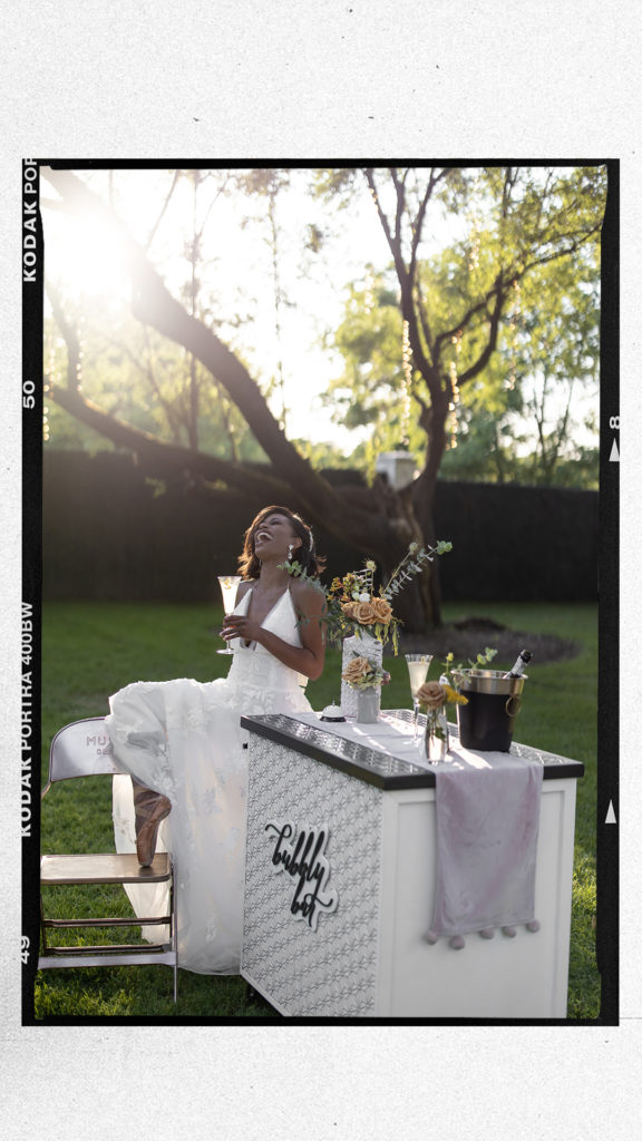 laughing bride in white gown at sunset drinking french 75