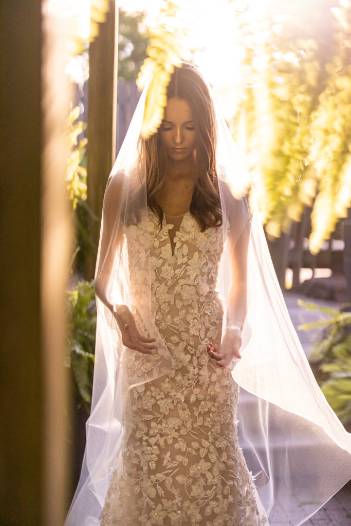 beautiful young bride in designer gown with backlit sunset light