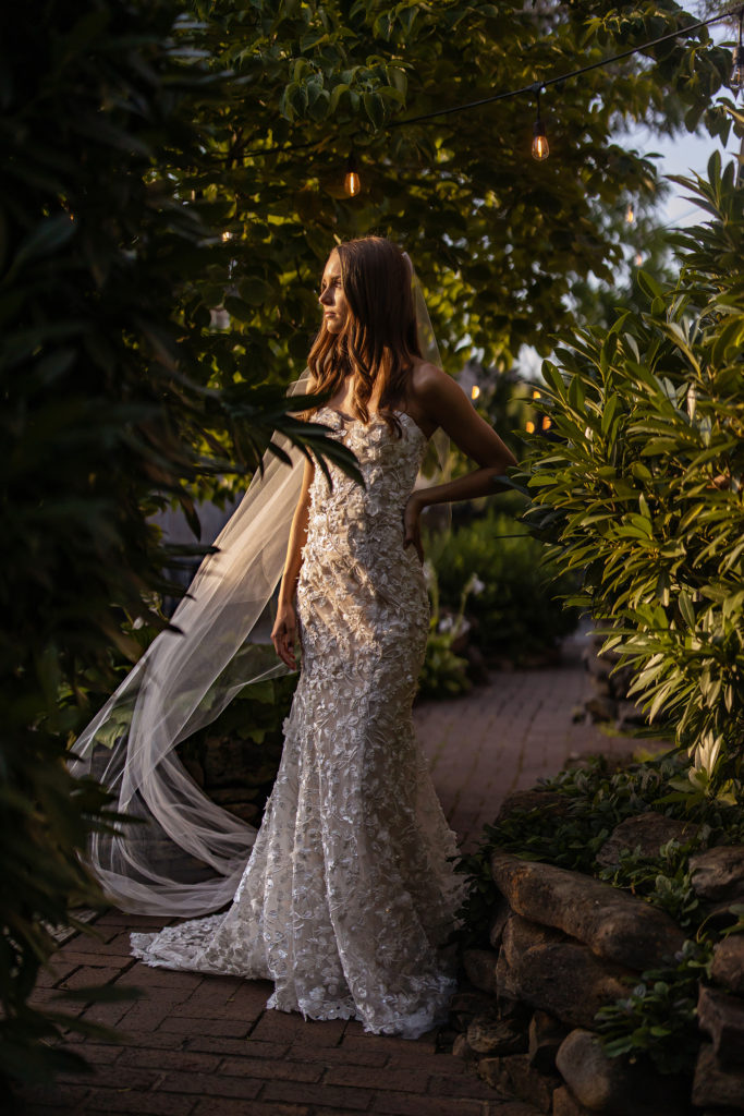 beautiful young bride in designer gown with sidelit sunset light