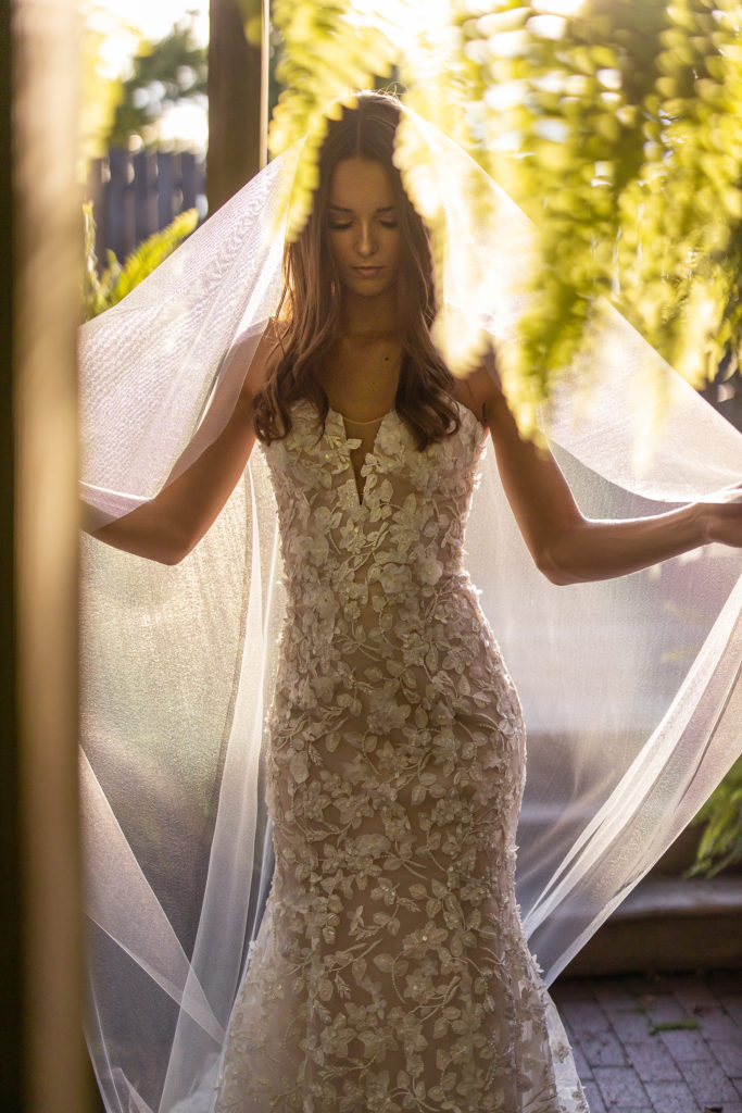 beautiful young bride in designer gown with backlit sunset light