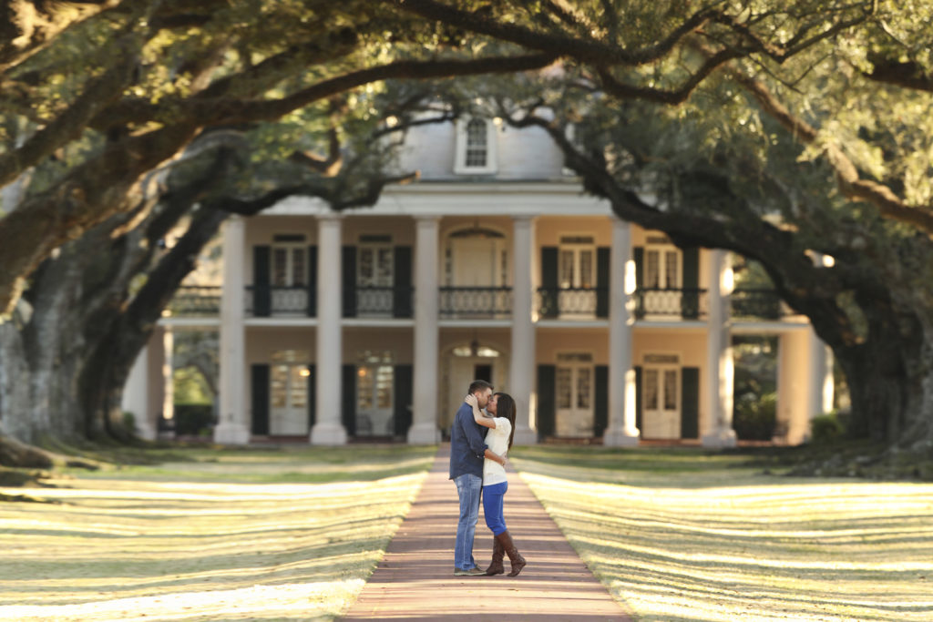 Southern engagement portraits at Houmas House in Louisiana with a long row of trees on each side.