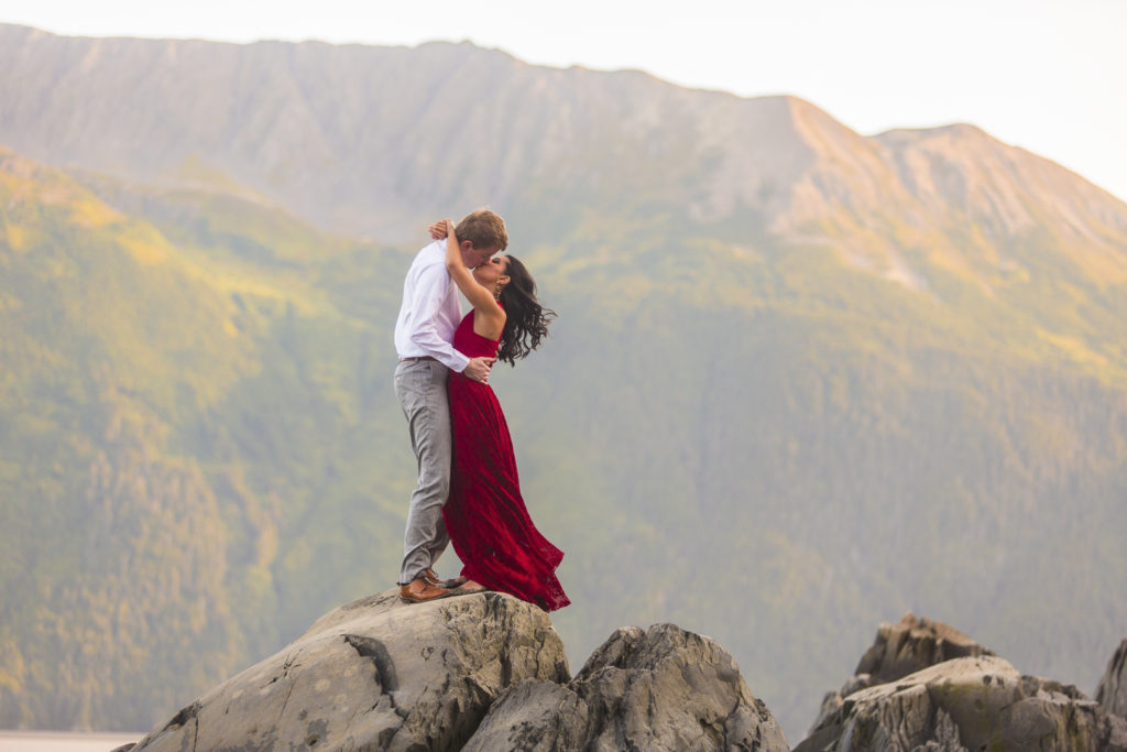 Pakistani bride and Alaskan groom kissing in front of the mountains in Alaska near Alyeska