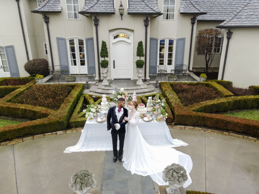 Aerial shot of Bridgerton Wedding inspired by the Netflix show with a black groom and red-headed bride.