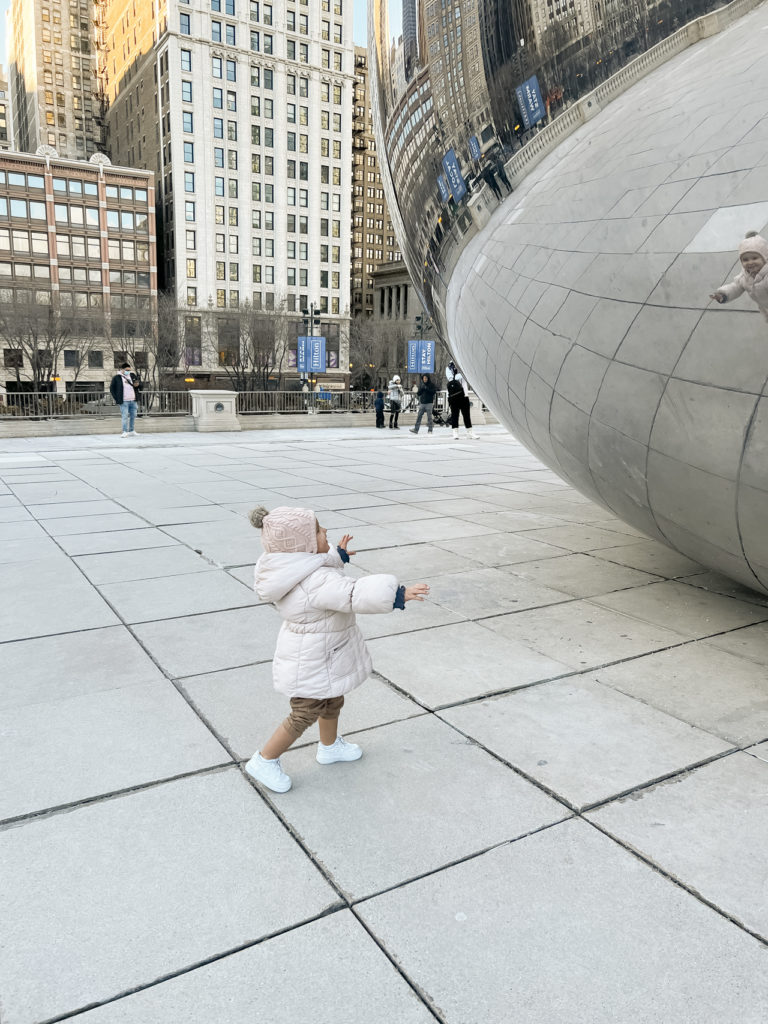 little girl running to the bean at Millennium Park in Chicago