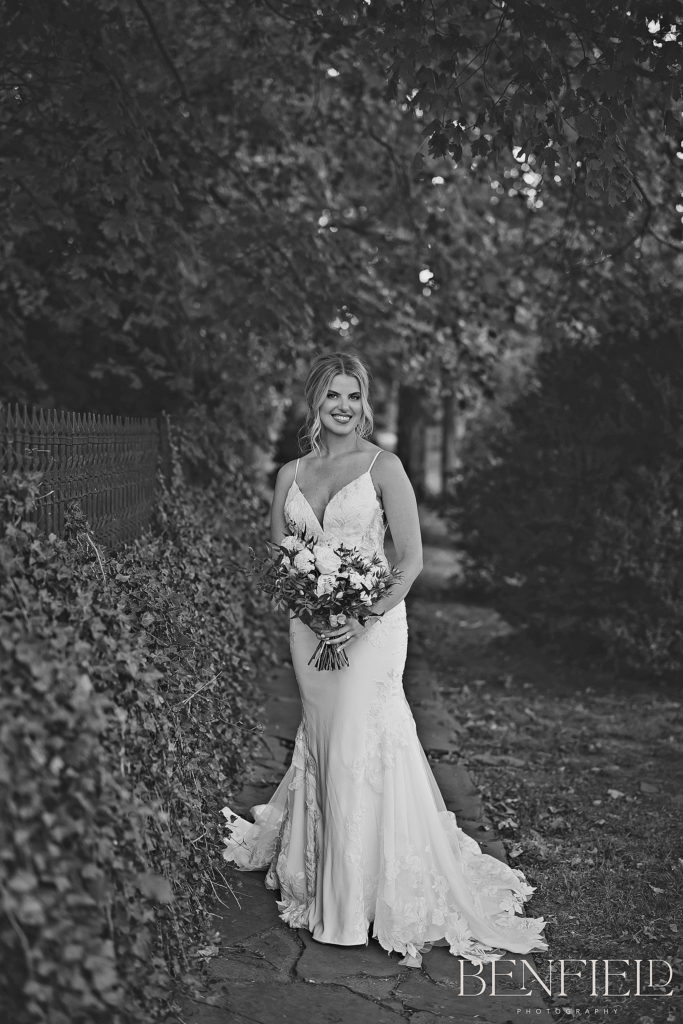 Black and White Luxury Bridal Portraits in Fayetteville Arkansas in front of an ivy wall with wrought iron fencing