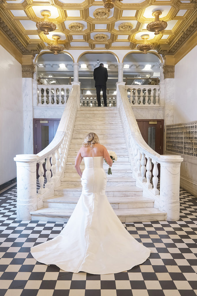 Chicago Athletic Association Wedding of the bride and groom during their first look on marble staircase