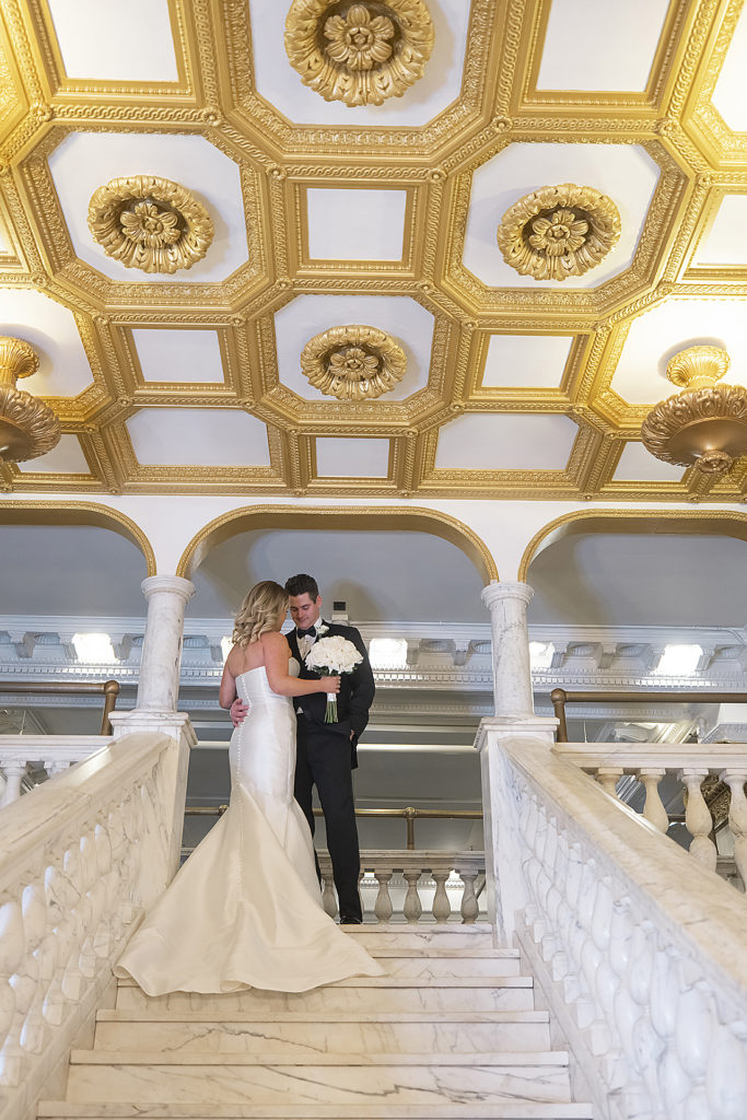 Chicago Athletic Association Wedding of the bride and groom during their first look on marble staircase