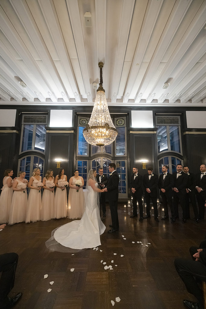 Chicago Athletic Association Wedding of the bride and groom during their ballroom ceremony with huge chandelier
