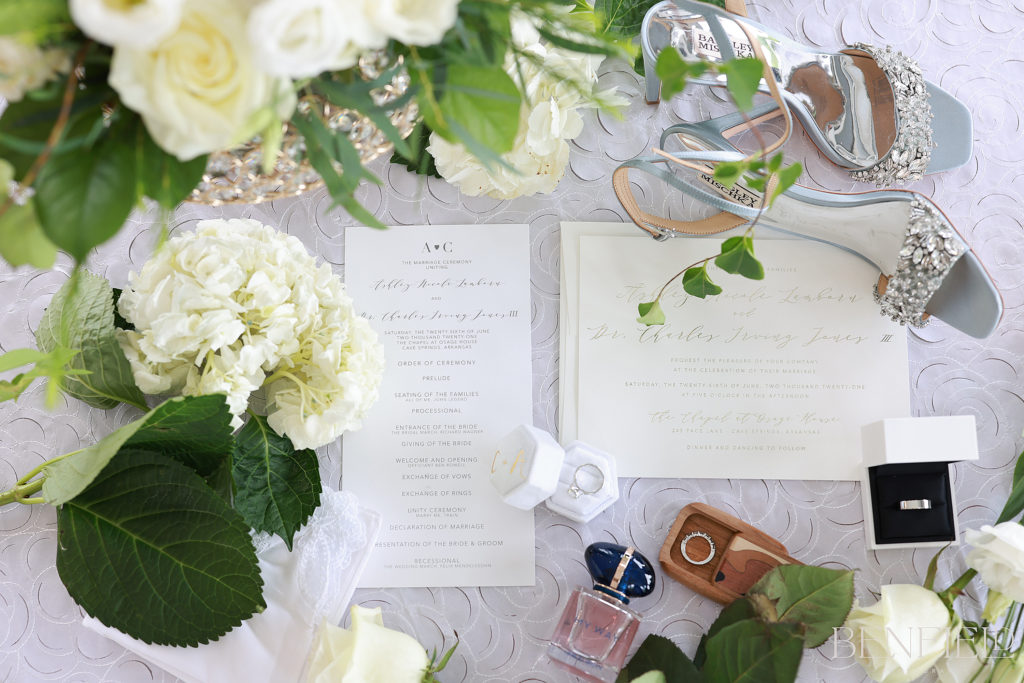 Osage House Wedding Details in a flatlay with invitation, rings, flowers, and shoes