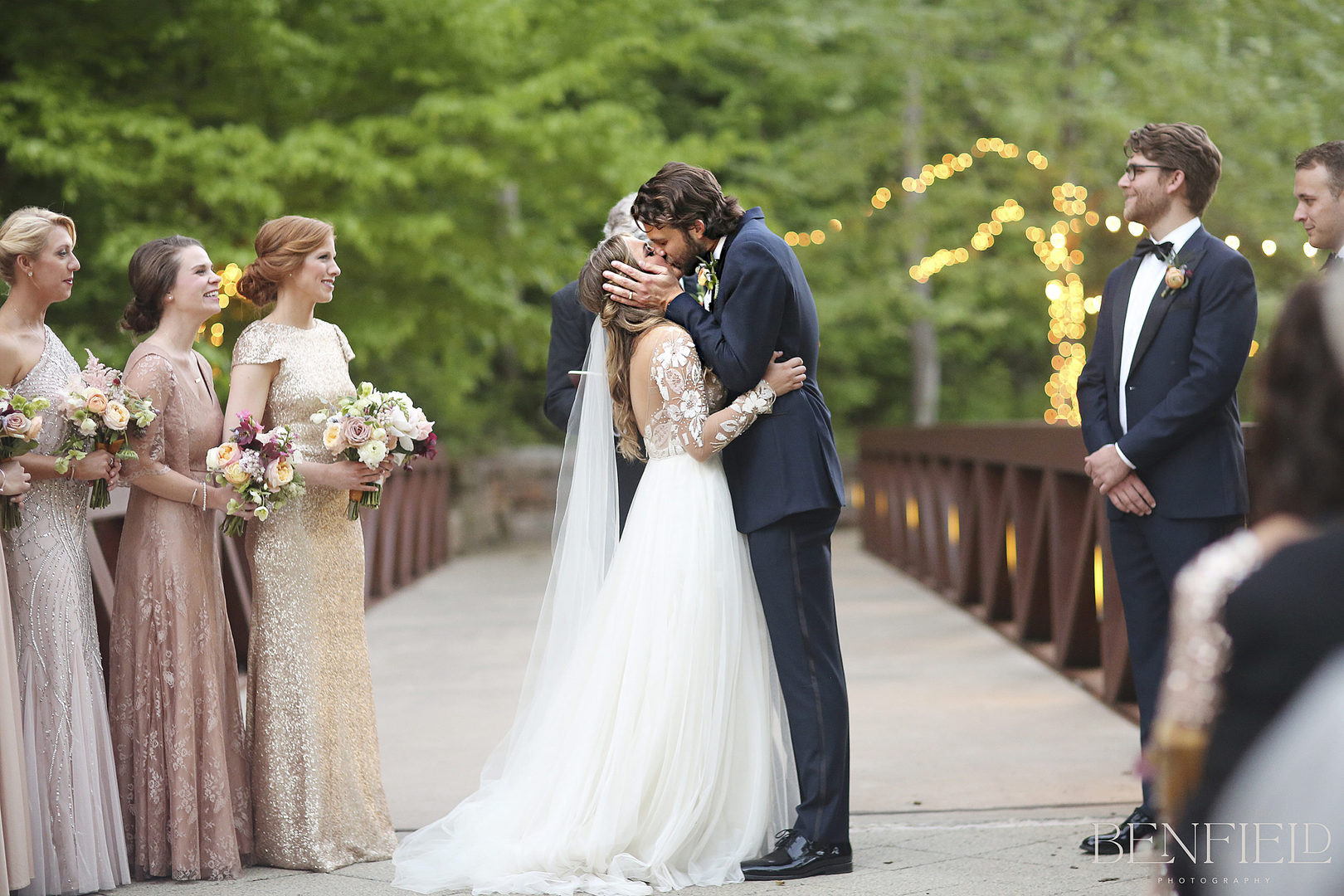 bride and grooms first kiss on a bridge at Crystal Bridges Museum in NW Arkansas