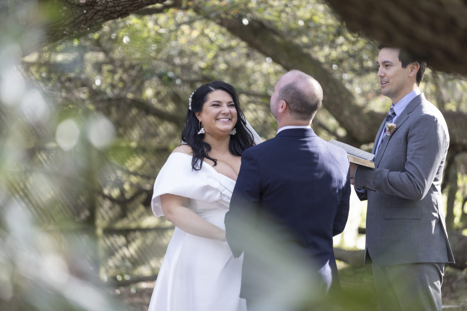 The bride and groom laugh during their wedding ceremony at Vintage Court in Covington LA