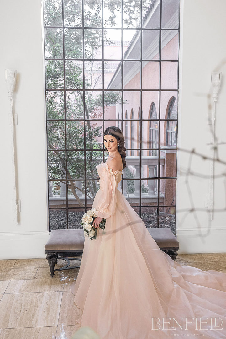 Monique Lhuillier Bridal Portraits of a young bride in a soft pink wedding dress that is strapless with a long train. This designer luxury bridal gown was photographed in Dallas Texas.