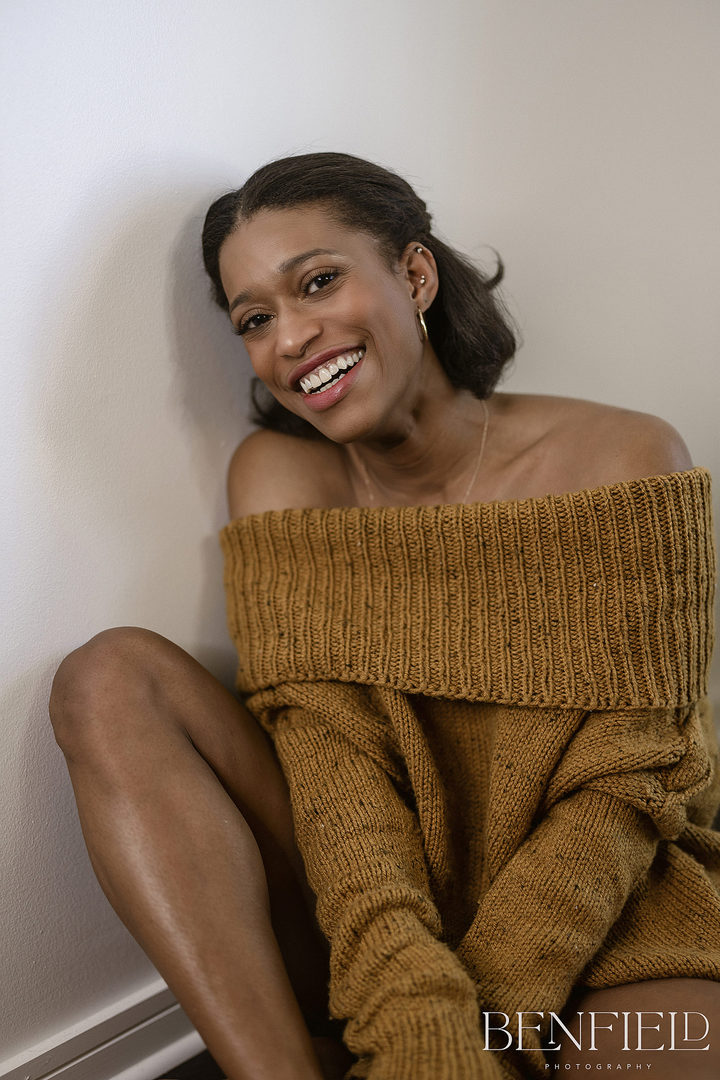 Supermodel Photographer model shoot of black model wearing a loose sweater and no bra laughing hard