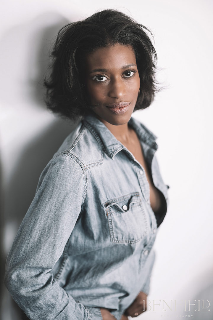 Gorgeous black female model posing with an open denim shirt showing side boob looking seductively at the camera