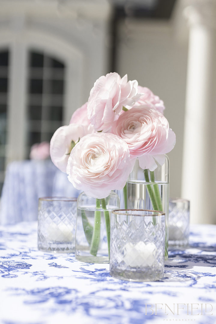 blush wedding color details showing how to choose your wedding colors should incorporate your flowers, as shown in this small floral arrangement of pink flowers on a blue and white linen