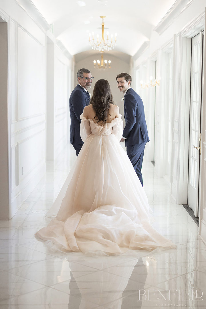 Special first look of bride tapping her dad and brother on the shoulder for their first look moment at her wedding at hillside estate in Crossroads Texas