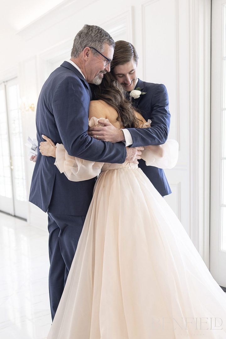 Special first look of bride tapping her dad and brother on the shoulder for their first look moment at her wedding at hillside estate in Crossroads Texas