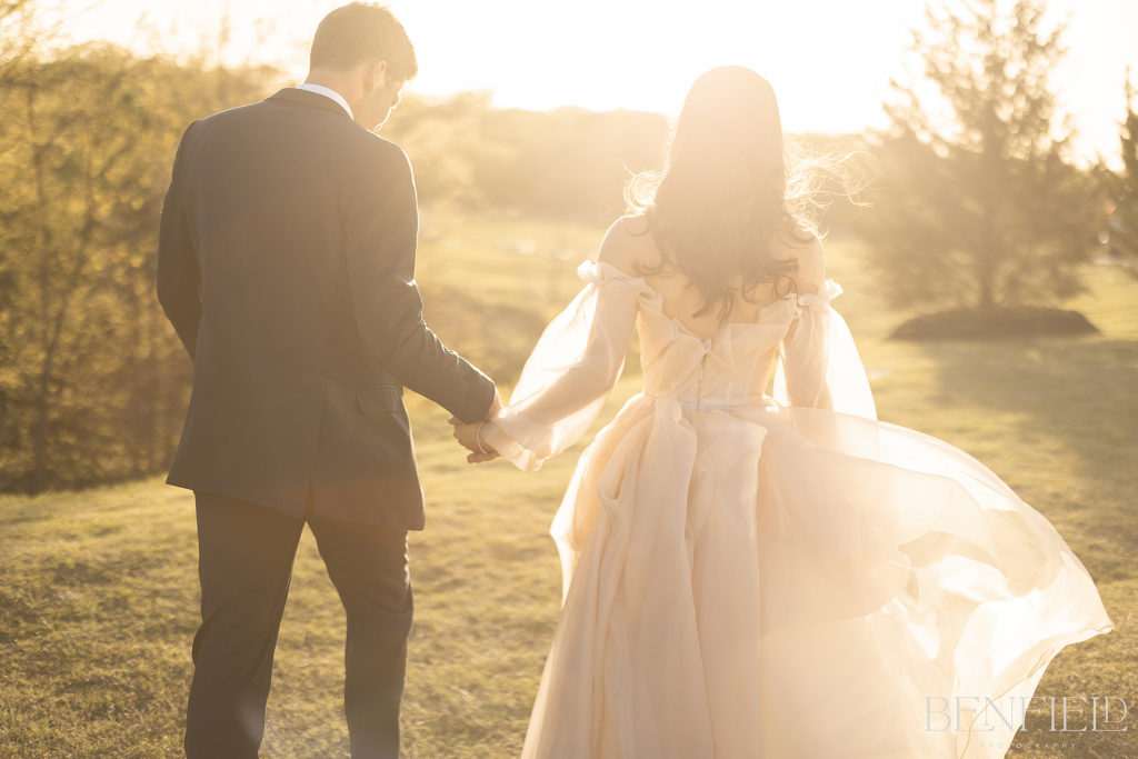 bride and groom walk off into the sunset during their wedding portraits at Hillside Estate.