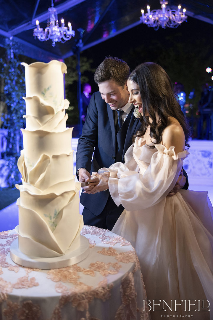 Bride and groom cut their luxury wedding cake during their wedding reception at Hillside Estate