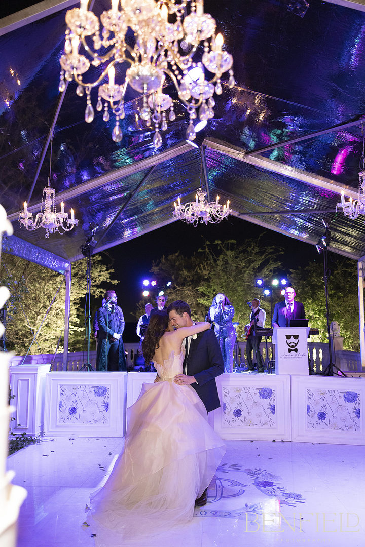 The bride and groom dance their last dance alone under the clear tent at their wedding reception