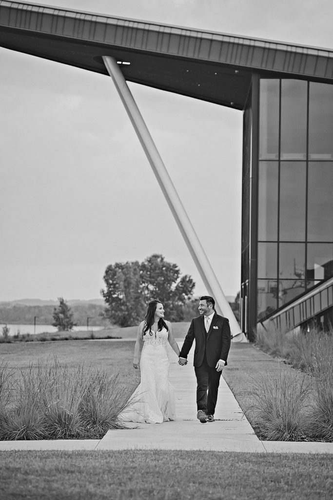 Wedding at US Marshals Museum and bride and groom are walking hand in hand outside