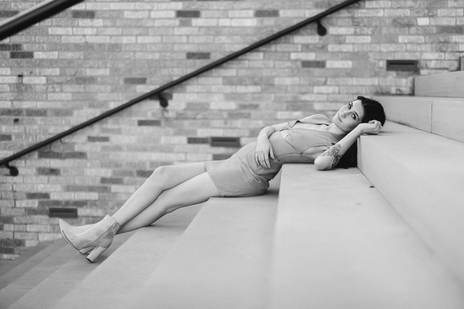 nwa model photo shoot with dark hair model lying down on a staircase