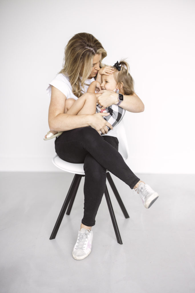 mom and daughter photo shoot in a white studio with a kids burberry outfit and a mom in black and white clothes.