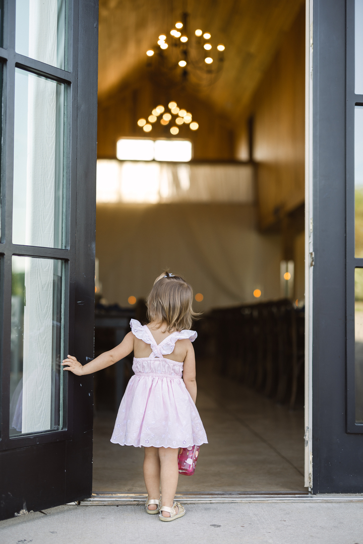 A young girl stands in the doorway of a luxury wedding reception.