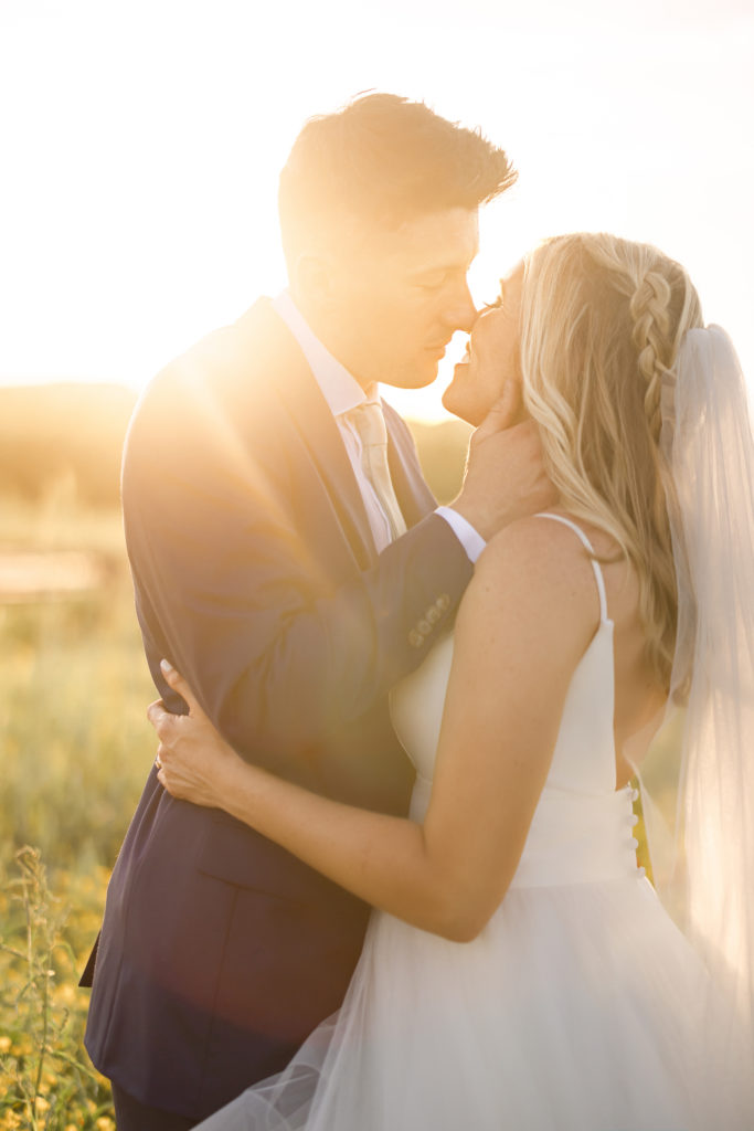 Warm and backlit timeless Wedding Portraits at Allenbrook Farms during golden hour as the bride and groom softly kiss