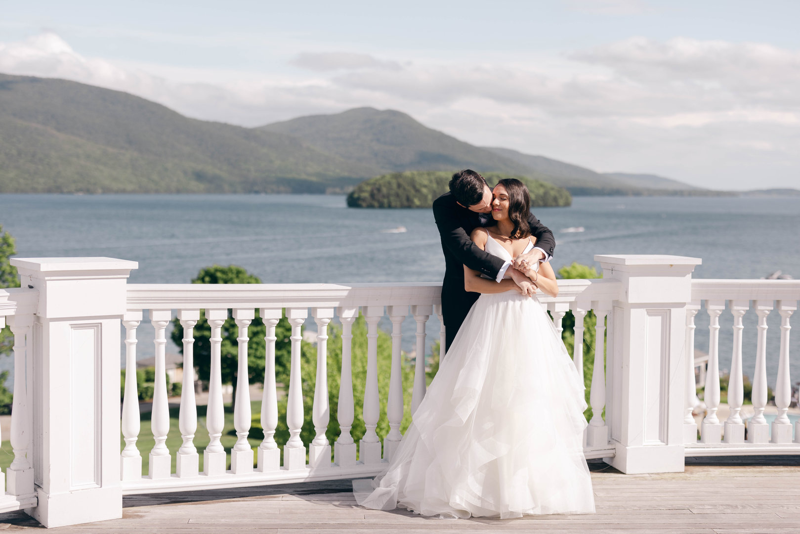 Wedding at The Sagamore showcasing the bride and groom on the 3rd floor balcony on Lake George.